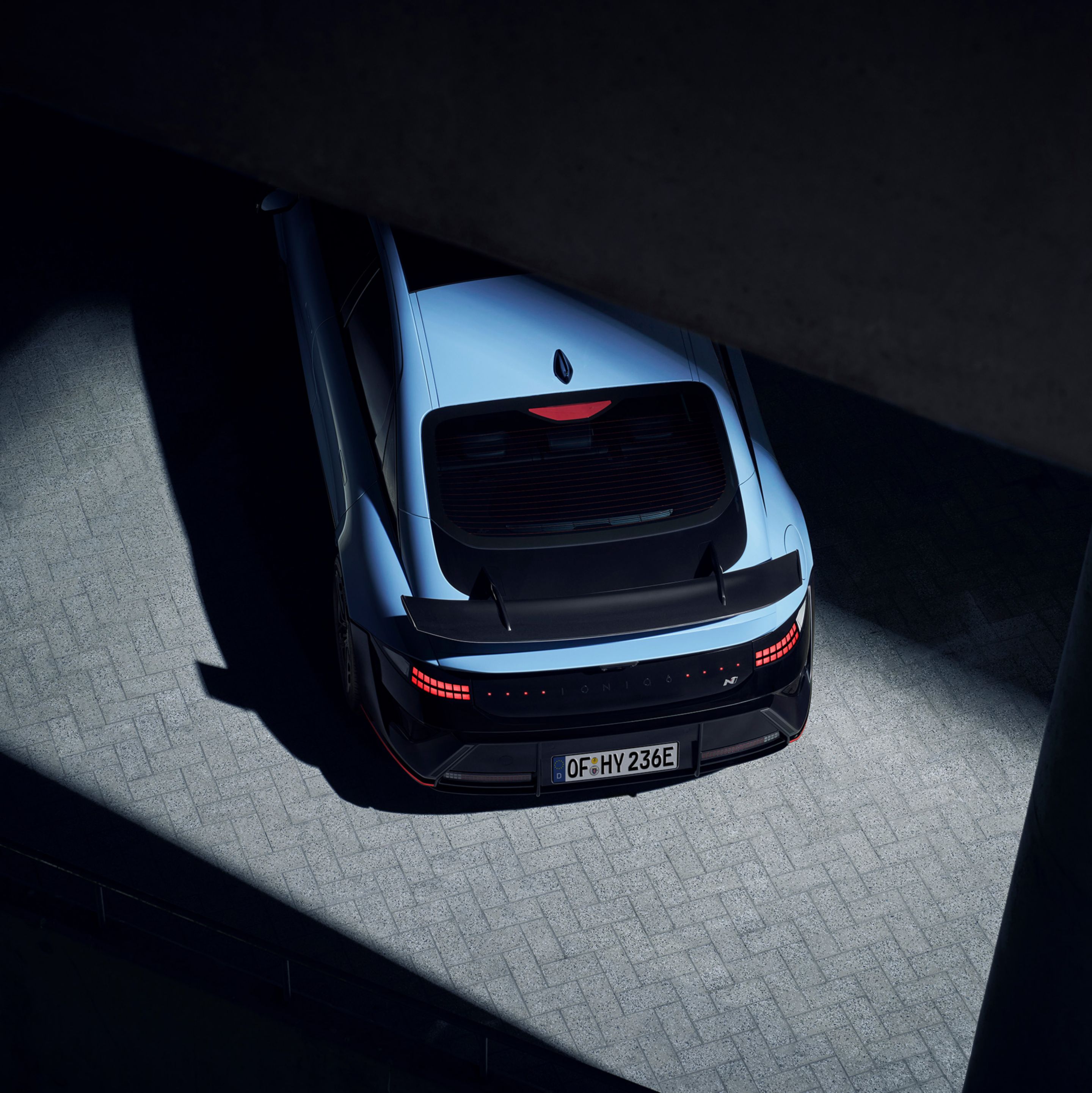 A Hyundai IONIQ 6 N felülnézetből egy híd alatt, hangsúlyozva a hátsó szárnyat és az áramvonalas profilt.