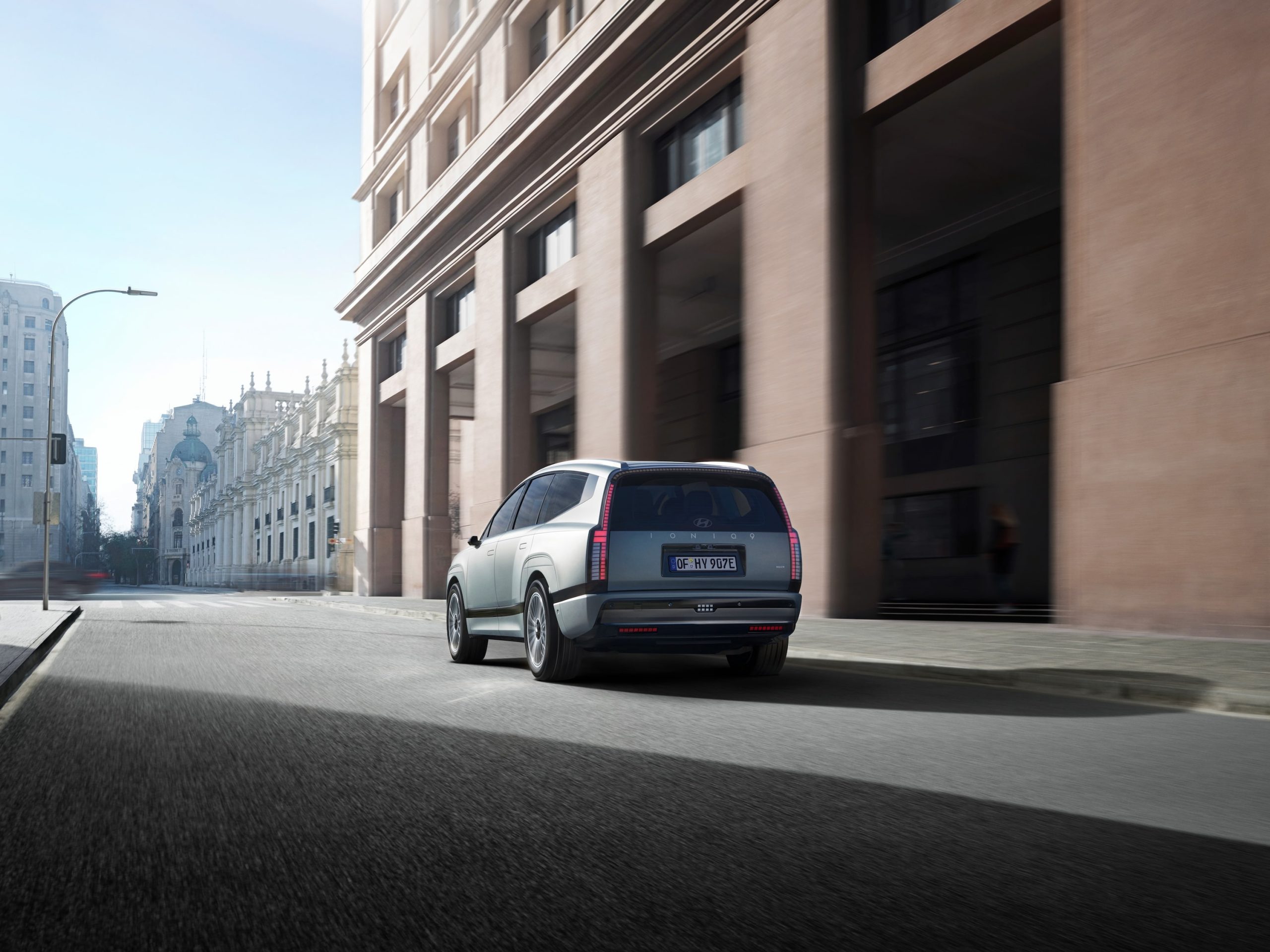 The rear view of the IONIQ 9 driving around town.